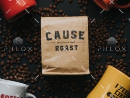Cause Roast coffee bag surrounded by coffee beans and colorful mugs on dark surface