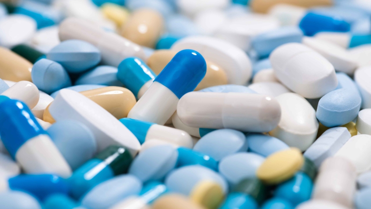 Close-up view of various colored capsules and tablets scattered together representing pharmaceutical products