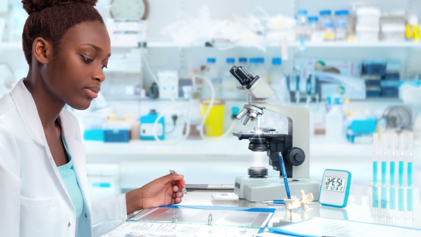 Scientist in a laboratory examining documents with a microscope and lab equipment in the background