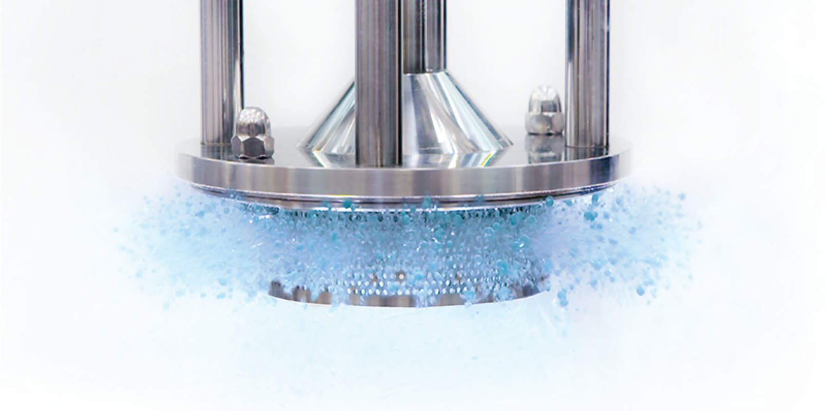 High-speed tablet coating machine spraying blue coating liquid over tablets