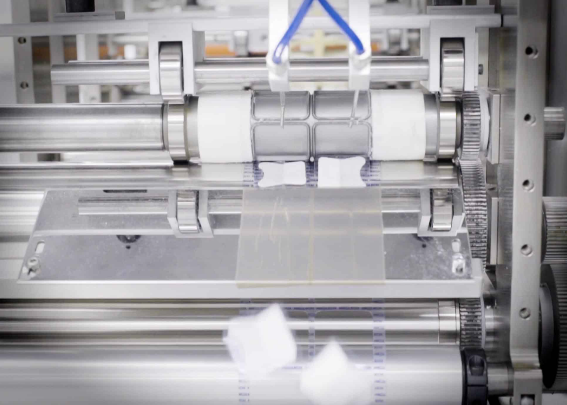 Automated packaging machine labeling product blister packs in pharmaceutical manufacturing